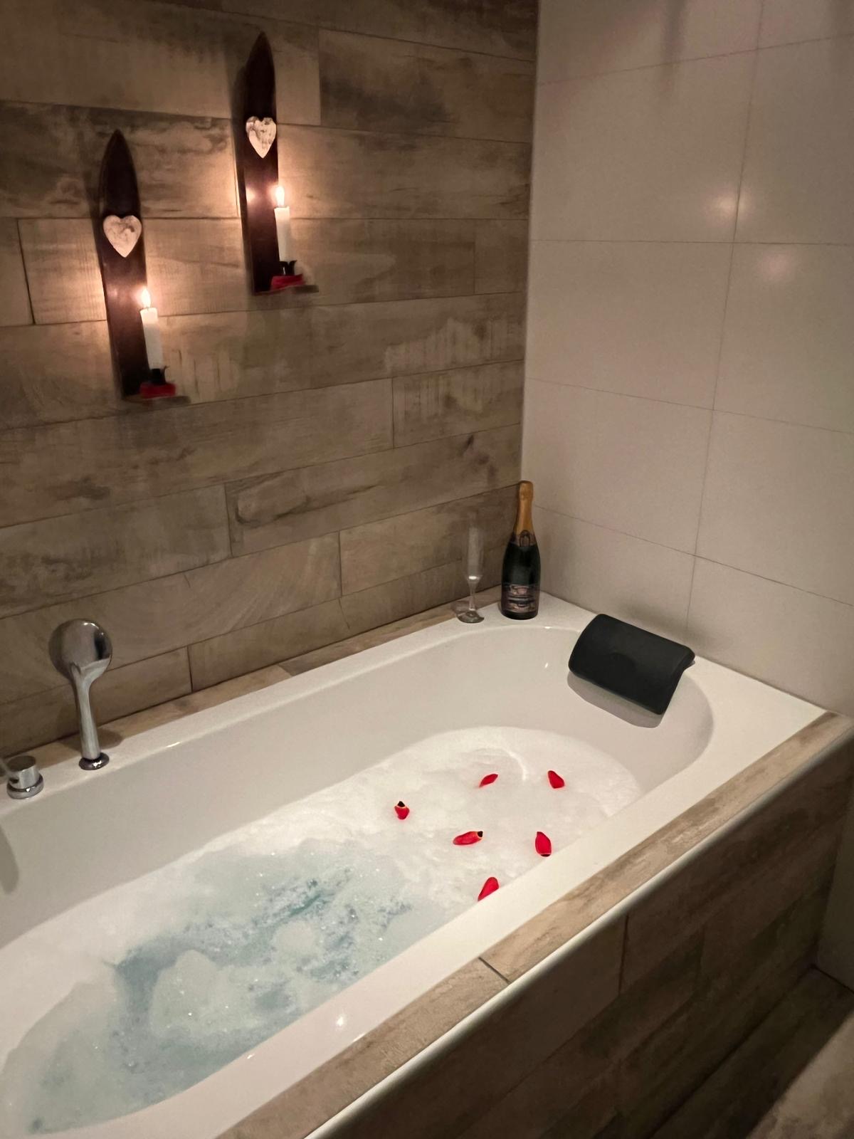 Badkar med levande ljus och badskum i stugan.