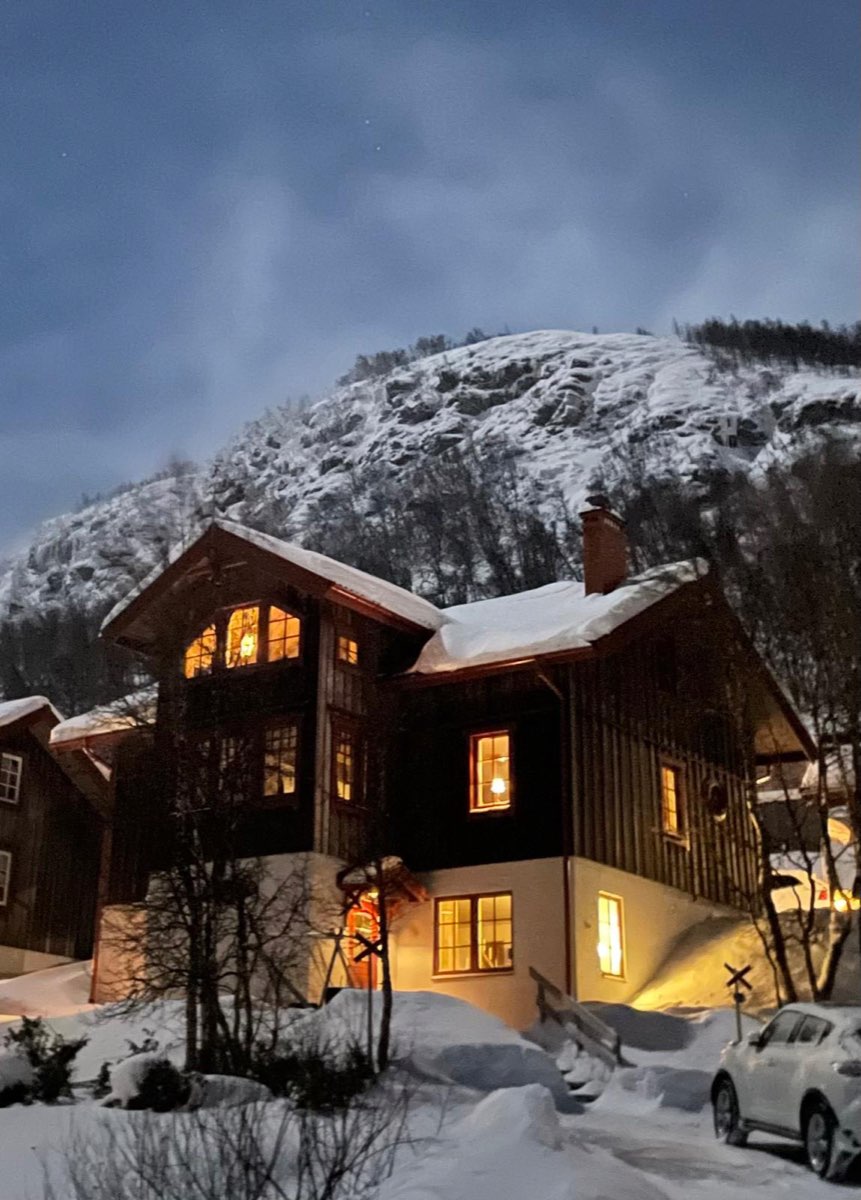 Helags-stugan i vinterljus med snö och fjäll bakom.